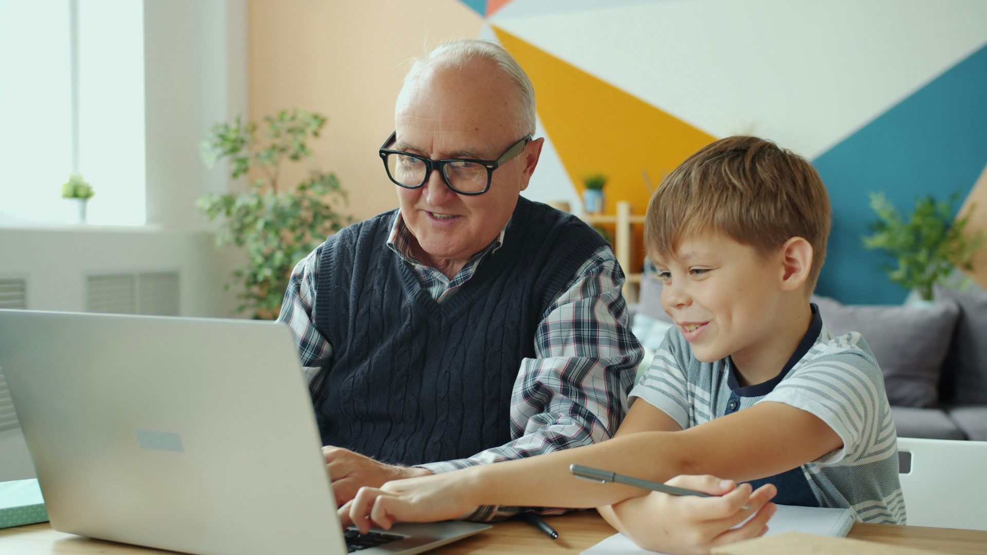 Grandfather and grandson looking at laptop together